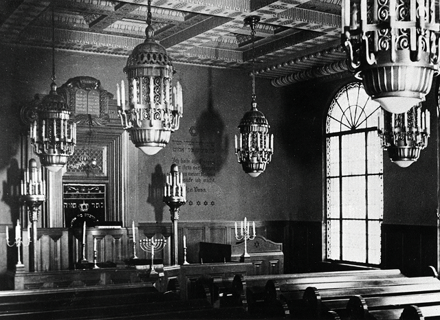 Aufnahme des alten Beetsaals, erschienen in „Berliner Architekturwelt“, 1916 - Waisenhaus Pankow Historischer Innenraum einer Synagoge mit kunstvollen Deckenleuchten und einem großen Fenster.