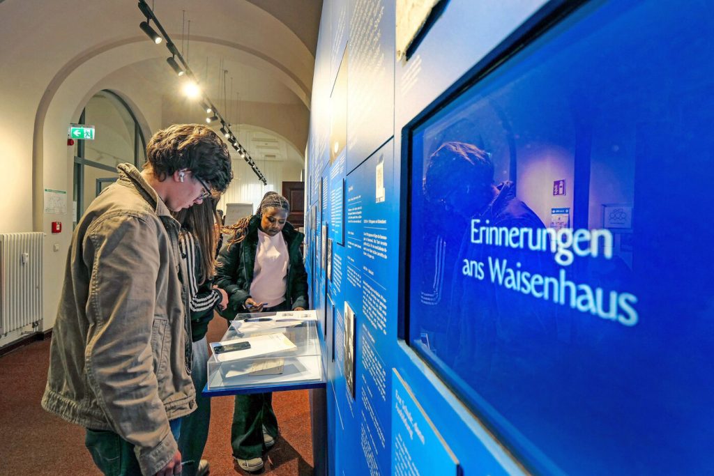 Ausstellung Schulklassen - Waisenhaus Pankow Schüler betrachten eine Ausstellungstafel mit dem Titel "Erinnerungen ans Waisenhaus".