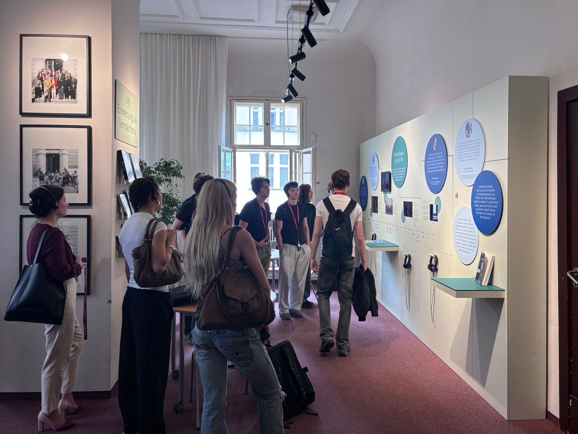 Ausstellungsansicht 3 - Waisenhaus Pankow Besucher betrachten eine Ausstellung mit Informationswänden und Exponaten in einem hellen Raum.